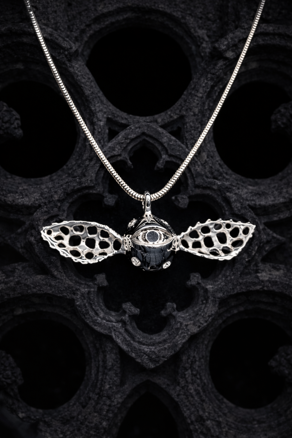 Pendentif gothique en argent 925 massif, œil ailé serti de moissanites VVS.
Chaîne maille serpent en argent 925 massif.